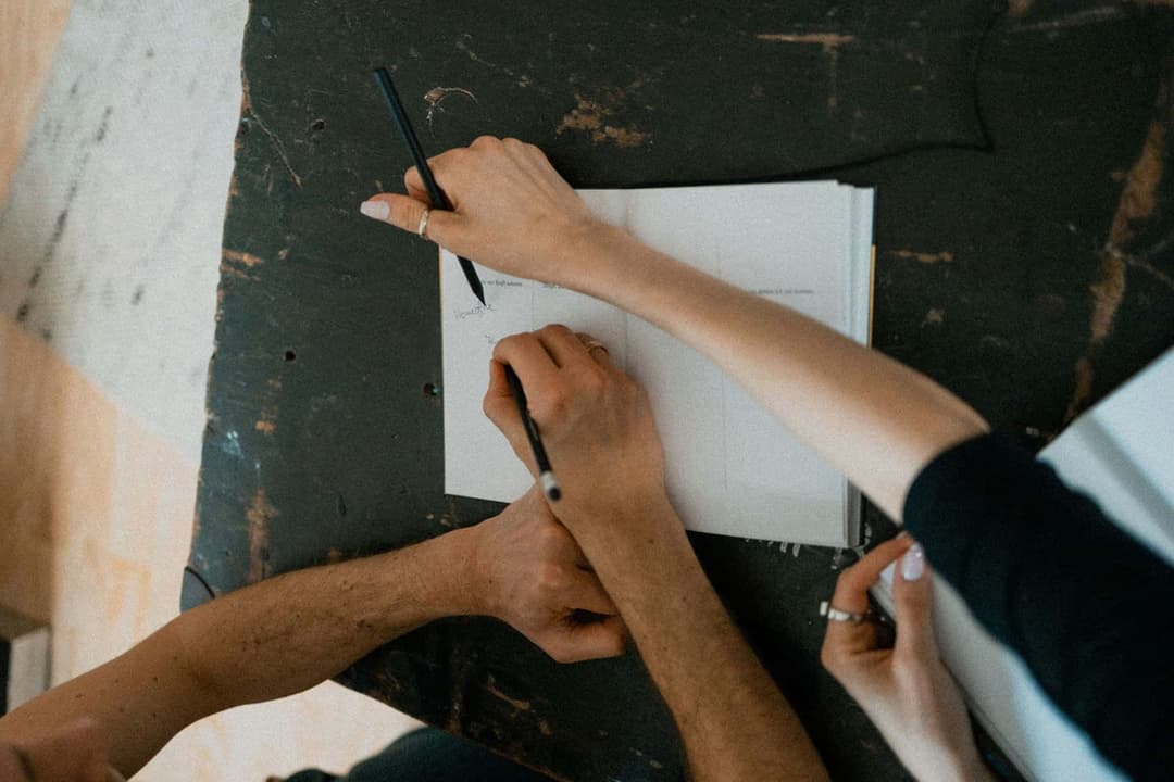 Hände, die in ein Notizbuch zeichnen